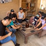 Voluntarios de Jaulas Abiertas reunidos planificando actividades en equipo alrededor de una mesa rústica.