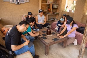 Voluntarios de Jaulas Abiertas reunidos planificando actividades en equipo alrededor de una mesa rústica.